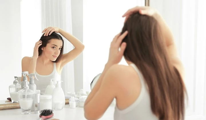 Frau prüft gesunde Kopfhaut Frau prüft gesunde Kopfhaut